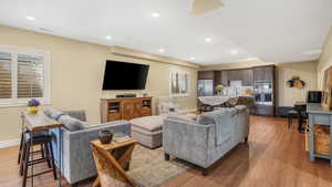 Living area with baseboards, light wood finished floors, and recessed lighting