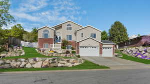 Traditional-style home featuring central air condition unit, fence, an attached garage, brick siding, and concrete driveway