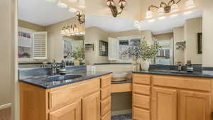 Primary Bathroom featuring a sink and two vanities