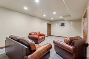 Living room featuring baseboards, light carpet, visible vents, and recessed lighting