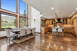 Dining room with a mountain view, recessed lighting, a chandelier, dark wood-style flooring, and baseboards