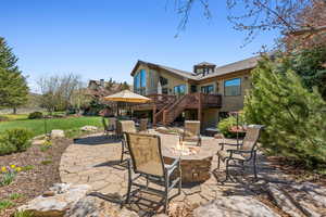 View of patio / terrace featuring a wooden deck, stairs, and a fire pit