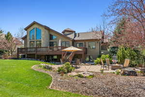 Rear view of property featuring a fire pit, a wooden deck, stairway, a yard, and a patio area