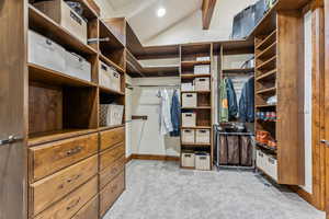 Spacious closet featuring lofted ceiling and carpet flooring