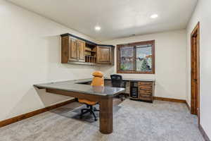 Office featuring built in desk, visible vents, baseboards, light carpet, and recessed lighting