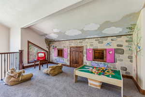 Playroom featuring a textured ceiling, carpet flooring, and baseboards