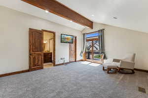 Living area featuring baseboards, visible vents, and vaulted ceiling with beams