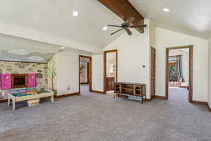 Rec room with baseboards, a ceiling fan, carpet, and high vaulted ceiling