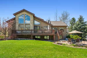 Rear view of house with stairs, a deck, a patio area, and a yard
