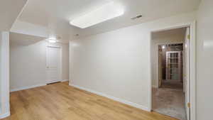 Spare room featuring baseboards, visible vents, and light wood-style flooring
