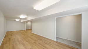Finished basement with baseboards and light wood finished floors