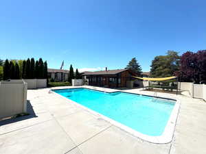 Pool featuring fence and a patio area