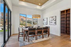 Dining room featuring wooden ceiling, a raised ceiling, a wealth of natural light, and baseboards
