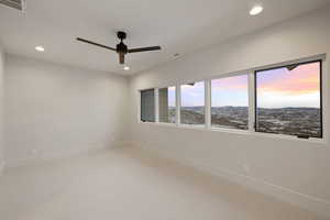Carpeted empty room with ceiling fan, baseboards, visible vents, and recessed lighting