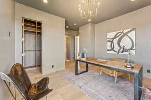 Office with a notable chandelier, recessed lighting, and wood finished floors