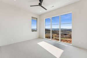 Unfurnished room featuring a mountain view, visible vents, recessed lighting, ceiling fan, and carpet flooring