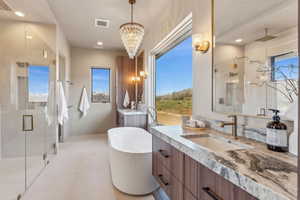 Bathroom featuring an inviting chandelier, visible vents, a sink, a shower stall, and two vanities