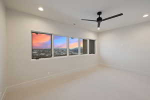 Spare room featuring carpet, a ceiling fan, visible vents, baseboards, and recessed lighting