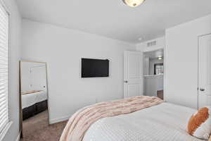 Bedroom with visible vents, baseboards, and carpet floors