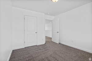Unfurnished bedroom with baseboards and carpet flooring