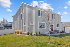 Rear view of house featuring a fenced backyard, a yard, central AC, and board and batten siding