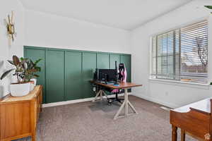 Carpeted office with wainscoting, a decorative wall, and baseboards