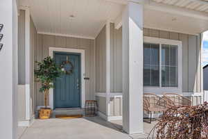 Entrance to property with board and batten siding and covered porch