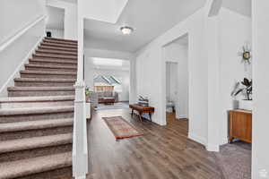 Entrance foyer featuring stairway, baseboards, and wood finished floors