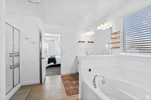 Ensuite bathroom featuring a stall shower, vanity, ensuite bathroom, and a garden tub