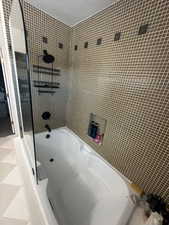 Full bath featuring  shower combination and a textured ceiling