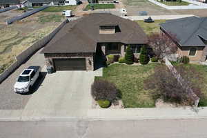 View of front of house with a garage, cooling unit, fence, brick siding, and driveway