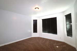 Empty room with carpet flooring and baseboards