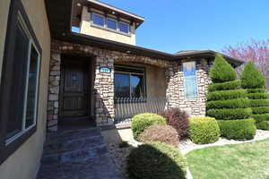 Entrance to property featuring stucco siding and stone siding
