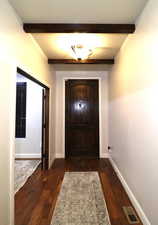 Doorway to outside with dark wood-style flooring, beamed ceiling, baseboards, and visible vents