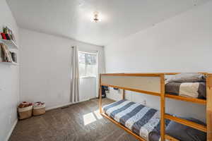 Carpeted bedroom with a textured ceiling and visible vents