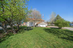 View of front of property with a front yard and a garage