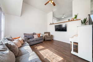 Living room with vaulted ceiling, baseboards, a ceiling fan, and wood finished floors