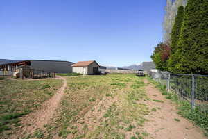 View of yard with an outdoor structure, a mountain view, and fence