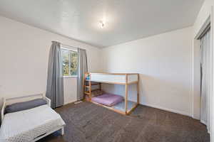 Carpeted bedroom featuring baseboards, visible vents, and a textured ceiling
