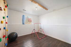 Game room with baseboards, visible vents, and wood finished floors