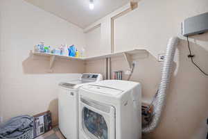 Washroom featuring separate washer and dryer and laundry area