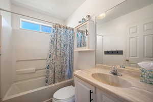 Full bathroom featuring toilet, shower / bath combo, and vanity