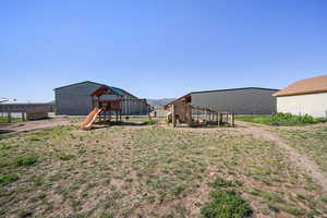 View of yard with a playground, an outbuilding, exterior structure, and fence