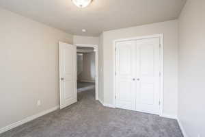 Unfurnished bedroom with baseboards, a closet, and carpet floors