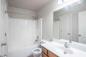 Bathroom featuring shower / bathing tub combination, vanity, and toilet