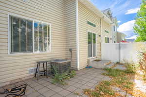 View of patio featuring cooling unit and fence