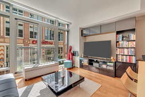 Living area with a healthy amount of sunlight and wood finished floors