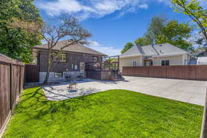 Rear view of property with a patio area and a deck, seperate entrance to the basement unit.