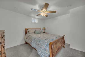 Bedroom with carpet, baseboards, and ceiling fan and large closet with mirrored doors.