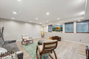 Living area featuring light wood-style floors, baseboards, and recessed lighting